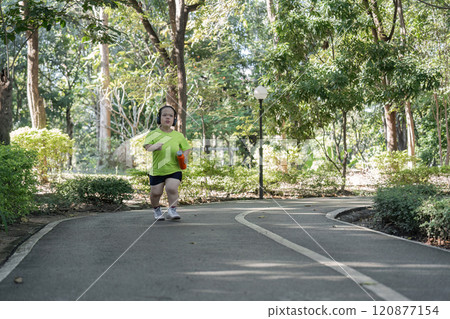 Empowered Young Woman with Disability Jogging for Fitness in a Park Setting, Embracing an Active Lifestyle and Overcoming Challenges 120877154