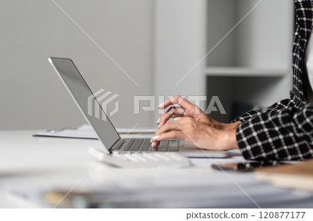 Close-Up of Businesswoman's Hands Typing on Laptop in Modern Office Setting for Professional and Corporate Use 120877177
