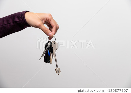 Woman's hand holding a house key Woman's hand holding a house key 120877307