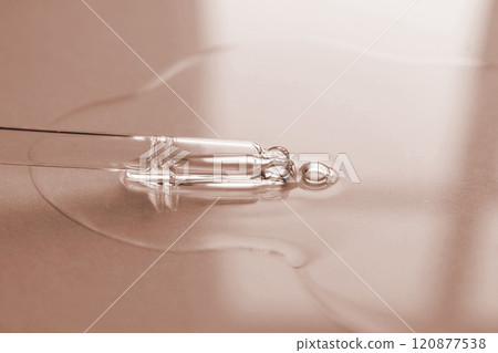 Pipette with oil or serum on a golden background. 120877538