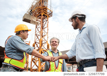 Team of workers at construction site with heavy machines. Team of workers at construction site with heavy machines. 120877799
