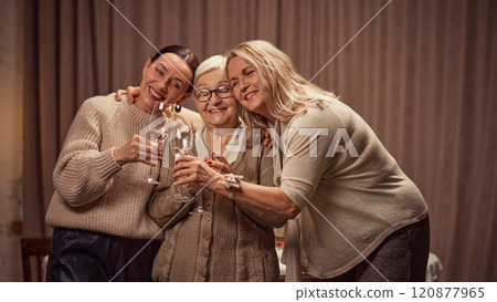 Happy Mothers day. Two elderly women, daughter's greeting their old mother with her day, drinking wine, laughing, showing respect and love Happy Mothers day. Two elderly women, daughter's greeting their old mother with her day, drinking wine, laughing, showing respect and love 120877965