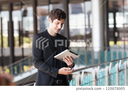 Smart and good looking businessman using digital tablet. 120878005