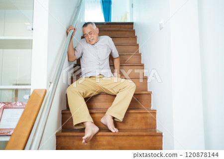 Senior male adult has an accident while walking on staircase. 120878144