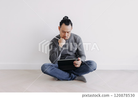 Creative freelance man sitting on the floor working with tablet. 120878530
