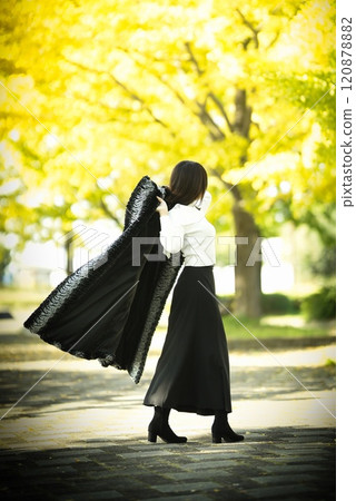 Back view of a beautiful woman in autumn park 120878882