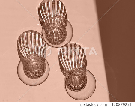 Mocha Mousse - color of the year 2025. Abstract Light and Shadow from drinking glasses on White Surface Mocha Mousse - color of the year 2025. Abstract Light and Shadow from drinking glasses on White Surface 120879251