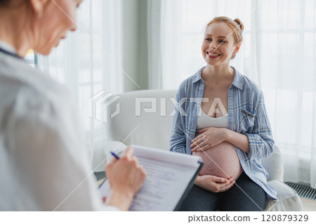 Female doctor examining pregnant woman in doctor office. Pregnant girl patient have consultation in hospital. Gynecologist doctor consulting patient about pregnancy. Visit to doctor medical checkup Female doctor examining pregnant woman in doctor office. Pregnant girl patient have consultation in hospital. Gynecologist doctor consulting patient about pregnancy. Visit to doctor medical checkup 120879329