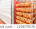 Sausage production line showing smoked sausages hanging in a modern food processing facility 120879536