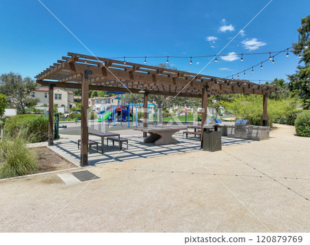Covered gathering area in city park with green wood picnic tables Covered gathering area in city park with green wood picnic tables 120879769