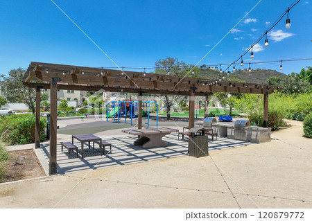 Covered gathering area in city park with green wood picnic tables Covered gathering area in city park with green wood picnic tables 120879772