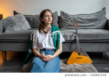 Bored female musician sit on floor with balalaika, take break from play. New instrument learn skill 120881548