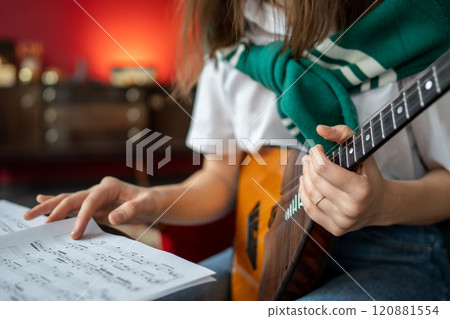 Woman hand flips through sheet music for balalaika. Ethnic musical instrument practice, tune lesson 120881554