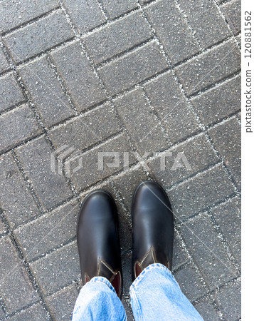 Winter boots on road with rock salt, top view. Chemical reagents to melt ice, prevent icing 120881562