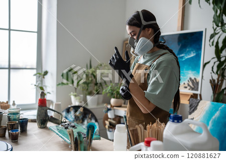 Female artist concentrates, enters state of focus, preparing for hard work on epoxy resin painting. 120881627