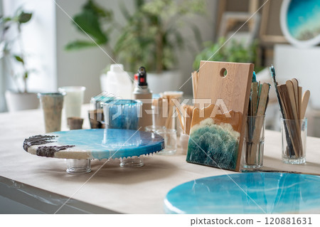 Artist workbench creating paintings artworks from epoxy resin. Table equipped for creative work. 120881631