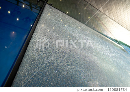 Shattered facade glass panel with visible cracks, no falling. Smart glass technology, damage control Shattered facade glass panel with visible cracks, no falling. Smart glass technology, damage control 120881784