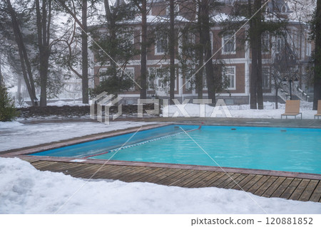 Outdoor swimming pool with warm water. Winter wellness spa resort with hot outdoor swimming pool.  120881852