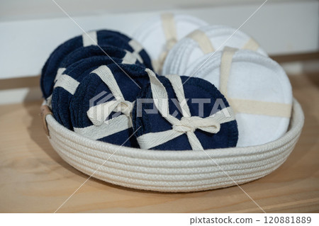 Reusable blue and white cotton pads, discs in knitted basket in bathroom. 120881889