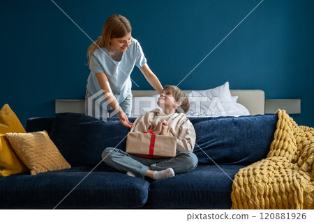 Small child son feeling excited while getting birthday present from loving mother at home Small child son feeling excited while getting birthday present from loving mother at home 120881926