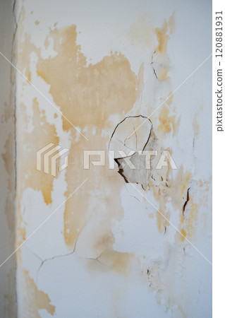 Damaged wall with chipped paint and plaster in traces of leak from faulty water supply at neighbours 120881931