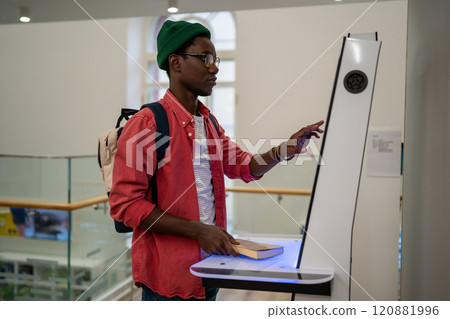 Progressive young man using self-service electronic terminal to pay in store without salesperson 120881996