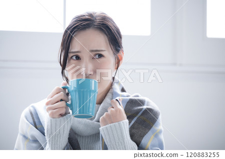 Do you have a cold? A woman drinking a hot drink who feels like she's starting to catch a cold or is feeling a bit chilly Do you have a cold? A woman drinking a hot drink who feels like she's starting to catch a cold or is feeling a bit chilly 120883255