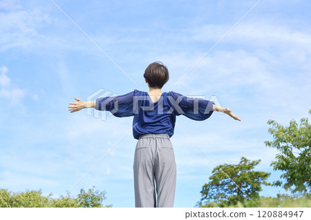 Woman taking a deep breath outside, back view Woman taking a deep breath outside, back view 120884947