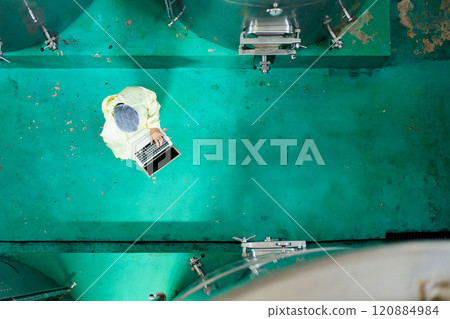 Factory engineer performs the examining inside the boiling chamber. Factory engineer performs the examining inside the boiling chamber. 120884984