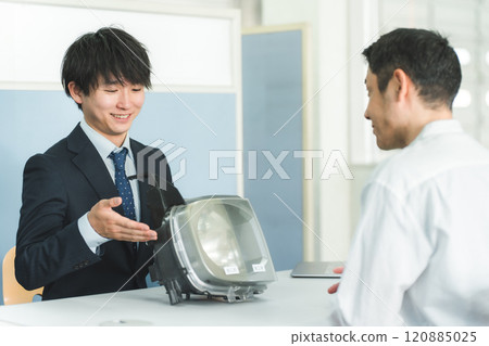 在汽車修理廠前台為顧客服務的服務前台和顧客 在汽車修理廠前台為顧客服務的服務前台和顧客 120885025