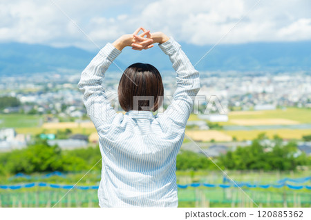 一個女人在旅行中一邊看著風景一邊伸展身體 一個女人在旅行中一邊看著風景一邊伸展身體 120885362