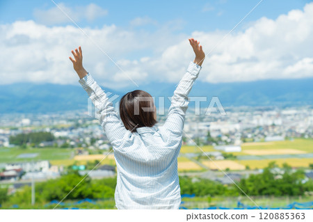 一個女人在旅行中一邊看著風景一邊伸展身體 一個女人在旅行中一邊看著風景一邊伸展身體 120885363