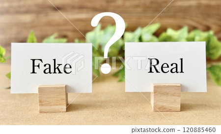 Fake and Real cards with question marks and ivy_brown board background 120885460