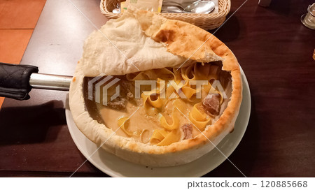 pasta with cheese and meat cooked in a frying pan and covered with a pancake 120885668