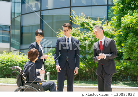 A woman in a wheelchair chatting in front of the office 120885928