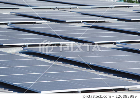 Arerial view showing a solar panels array on factory - warehouse rooftop close up. Solar cell array installed on the building rooftop, renewable and sustainable energy concept. 120885989