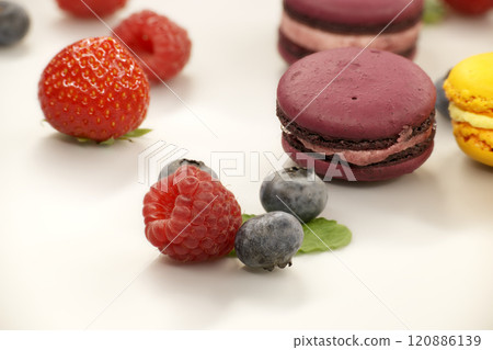 Vibrant scene of table filled with macaroons and fruits Vibrant scene of table filled with macaroons and fruits 120886139