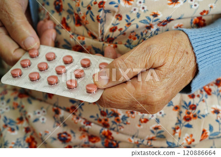 Asian elderly woman holding pill drug in hand, strong healthy medical. Asian elderly woman holding pill drug in hand, strong healthy medical. 120886664