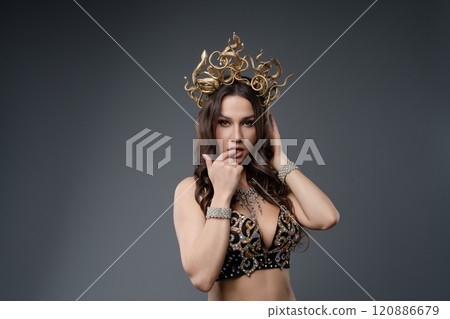 Elegant dancer showcases intricate crown in artistic studio setting 120886679