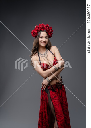Dancer in vibrant red costume with floral crown posing gracefully in studio Dancer in vibrant red costume with floral crown posing gracefully in studio 120886687
