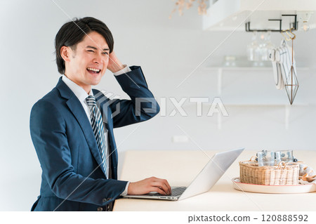 Young Asian businessman in a suit working at his dining table at home 120888592