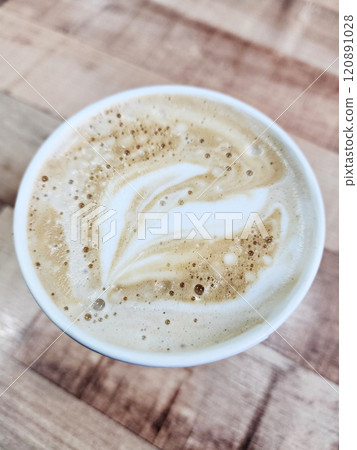 close up of latte coffee on wood table 120891028