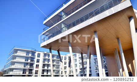 Modern high-rise apartment building in white, stand tall against a blue sky, exemplifying innovative urban architecture with sleek, angular designs. Modern high-rise apartment building in white, stand tall against a blue sky, exemplifying innovative urban architecture with sleek, angular designs. 120891252