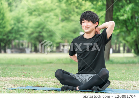 年輕的亞洲男子在森林/公園裡做瑜珈、皮拉提斯、冥想和正念 120891704