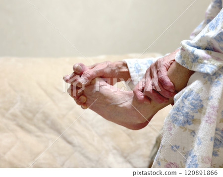 The hands of an elderly woman in pajamas with her hands between her toes The hands of an elderly woman in pajamas with her hands between her toes 120891866