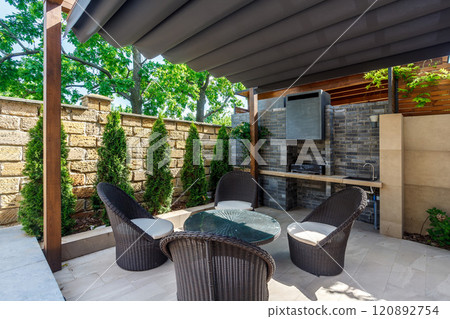 Backyard outdoor bbq zone with pergola, fireplace and hanging chair. Summer party place 120892754