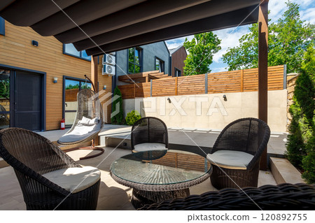Backyard outdoor bbq zone with pergola, fireplace and hanging chair. Summer party place 120892755