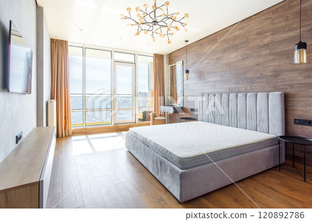 large modern bedroom bed with headboard warm wooden laminate on wall 120892786