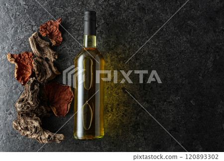 Bottle of white wine on a black stone background. 120893302