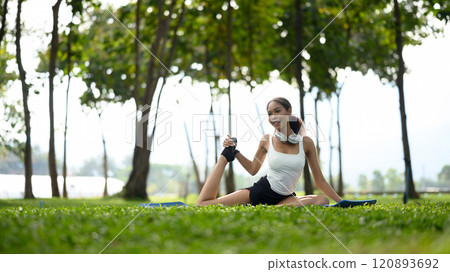 Young woman practicing yoga on fitness mat in a peaceful park Young woman practicing yoga on fitness mat in a peaceful park 120893692